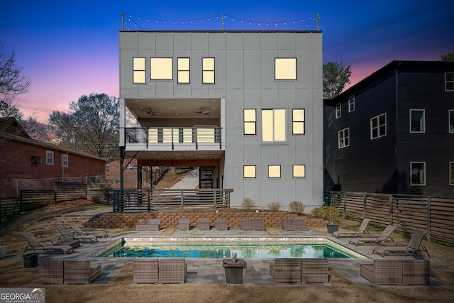 rear view of property with a patio area, a balcony, fence, and board and batten siding