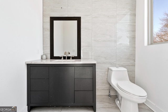 bathroom featuring toilet, marble finish floor, and vanity