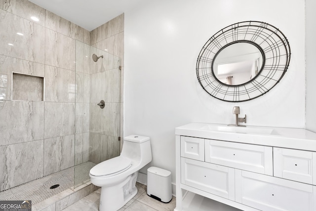 full bathroom featuring a tile shower, tile patterned floors, toilet, and vanity