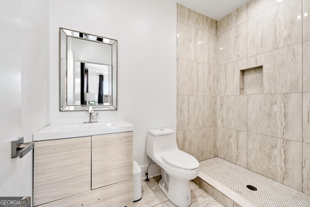 full bath featuring vanity, toilet, marble finish floor, and tiled shower