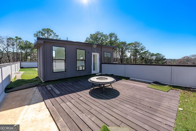 deck featuring an outdoor fire pit and fence