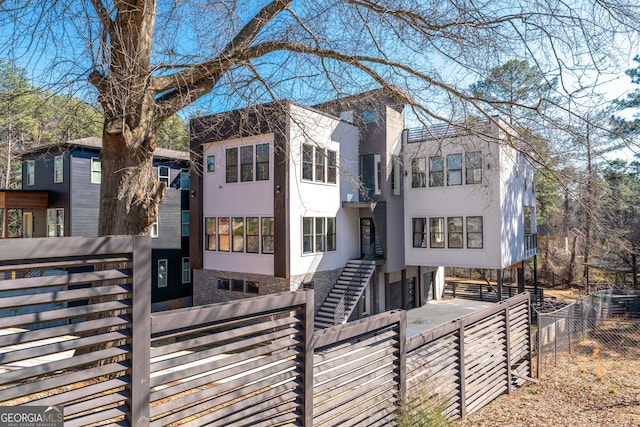 view of front of house featuring concrete driveway, a gate, a fenced front yard, and stucco siding