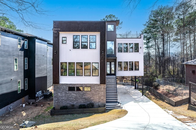 contemporary house featuring central air condition unit and stairs