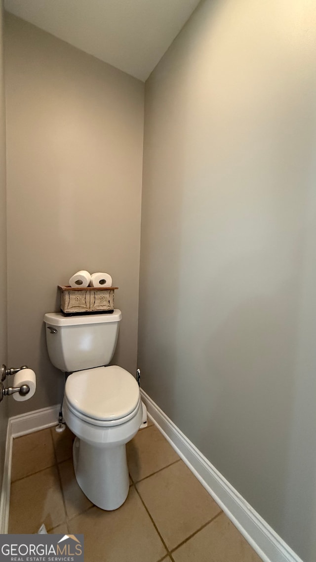 bathroom with tile patterned flooring, toilet, and baseboards