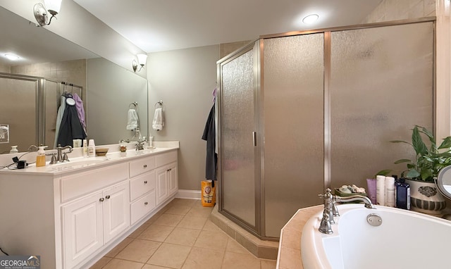 bathroom with a garden tub, double vanity, a sink, a shower stall, and tile patterned floors