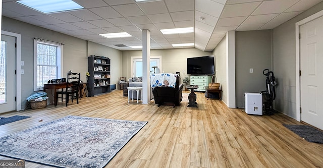 interior space with a drop ceiling and wood finished floors