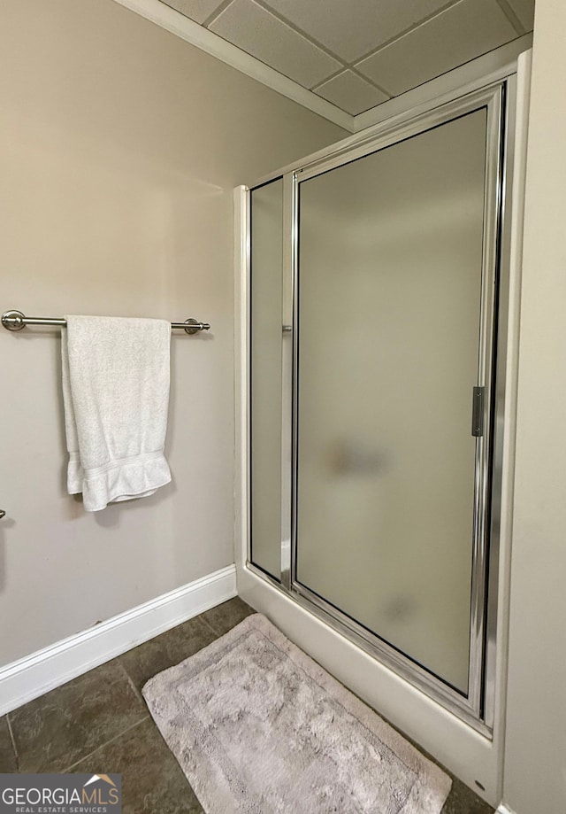 bathroom with a stall shower, tile patterned flooring, and baseboards