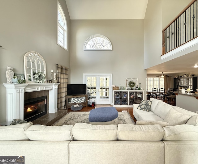 living room with french doors, a wealth of natural light, and a tile fireplace