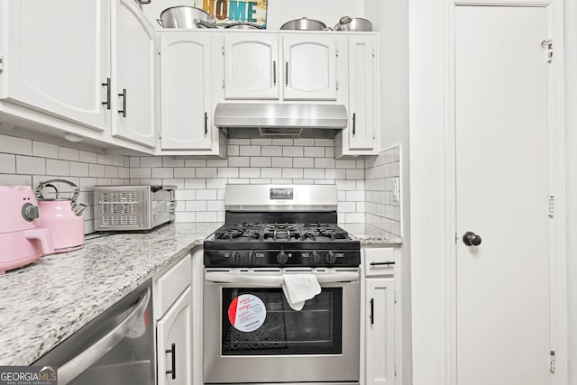 kitchen featuring appliances with stainless steel finishes, white cabinetry, backsplash, and extractor fan