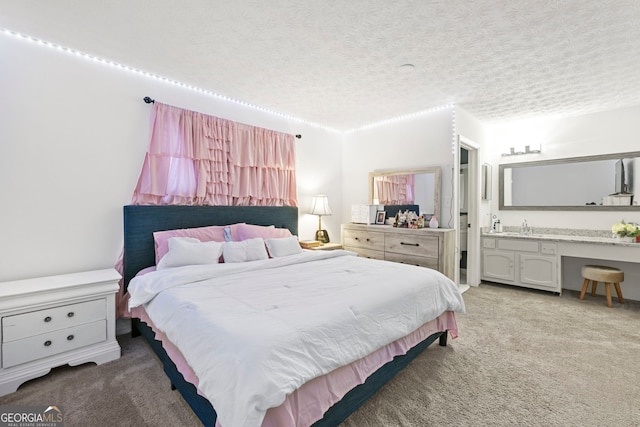 bedroom with ensuite bath, a textured ceiling, and carpet flooring