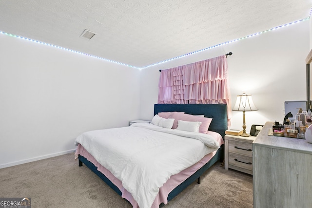 carpeted bedroom featuring visible vents, a textured ceiling, and baseboards