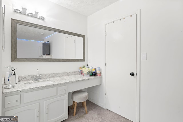 bathroom featuring a textured ceiling and vanity