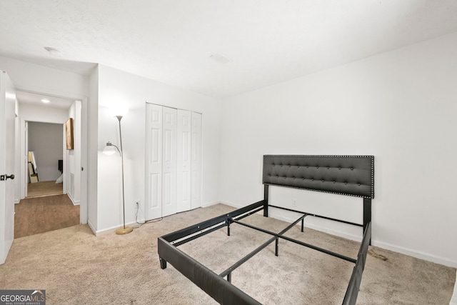 bedroom with carpet, baseboards, and a closet