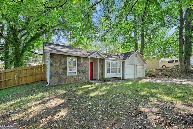 view of front of home featuring stone siding, an attached garage, fence, and driveway