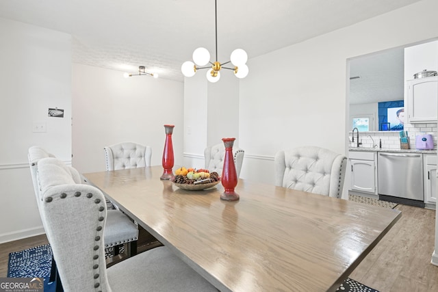 dining area with an inviting chandelier and wood finished floors