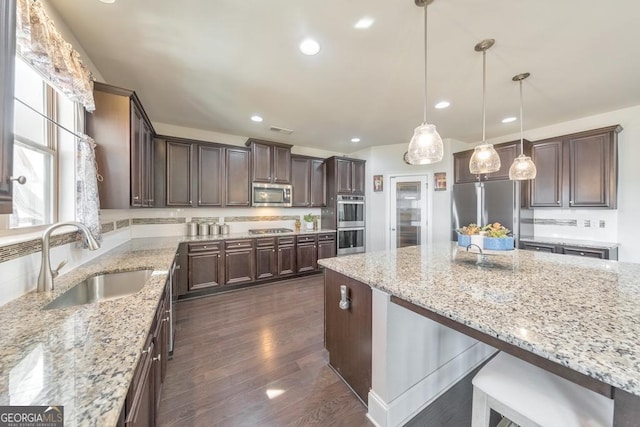 kitchen with visible vents, dark brown cabinets, backsplash, appliances with stainless steel finishes, and a sink