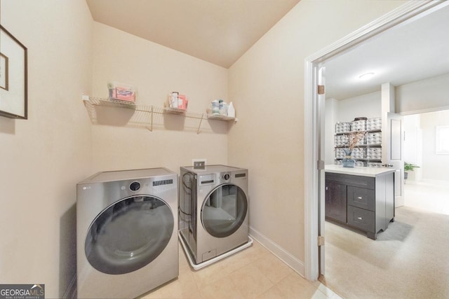 washroom with baseboards, laundry area, and washer and clothes dryer