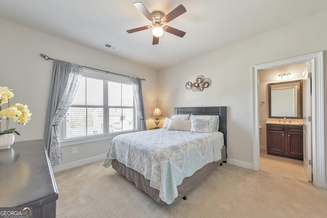 bedroom featuring visible vents, light colored carpet, ensuite bath, and baseboards