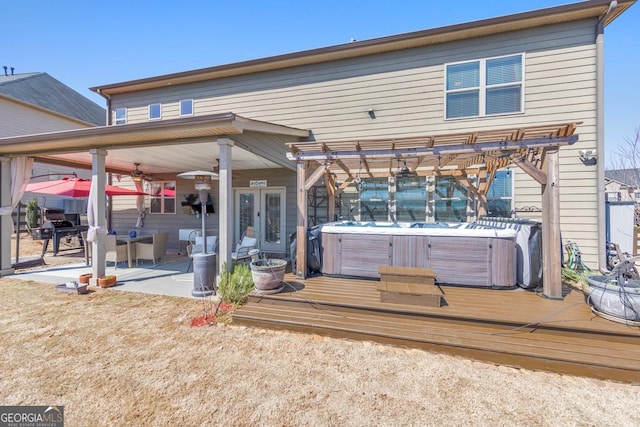 back of property featuring french doors, a hot tub, and a patio