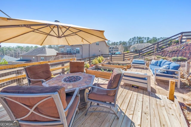 wooden deck featuring a residential view and an outdoor living space with a fire pit