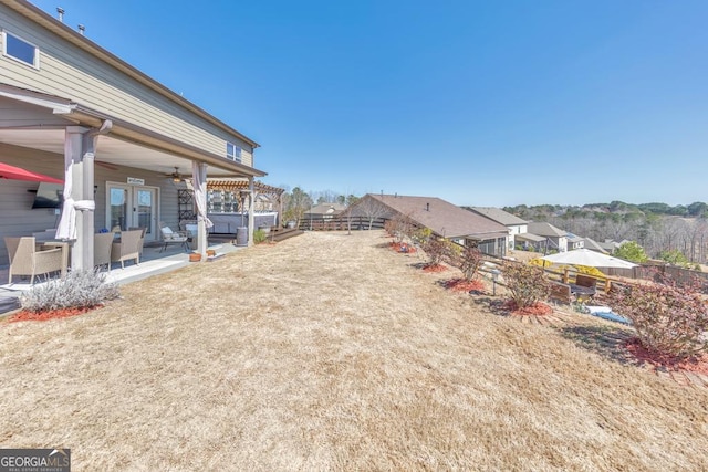 view of yard featuring french doors, a ceiling fan, a patio, and fence