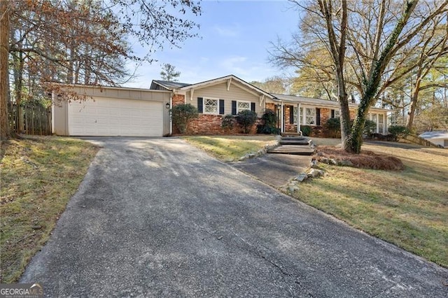 ranch-style house featuring a garage, brick siding, driveway, and a front lawn