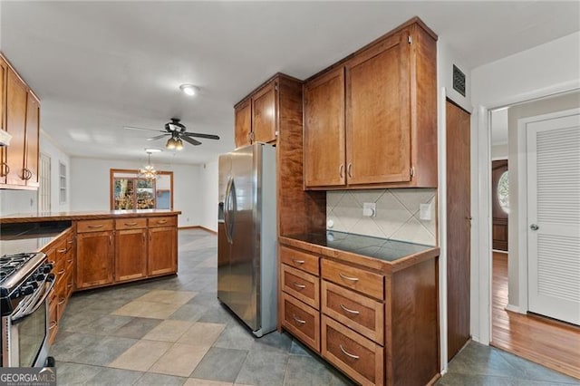 kitchen with visible vents, brown cabinetry, tile counters, appliances with stainless steel finishes, and a peninsula