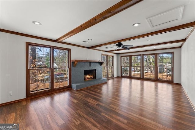 unfurnished living room featuring a brick fireplace, beamed ceiling, baseboards, and wood finished floors