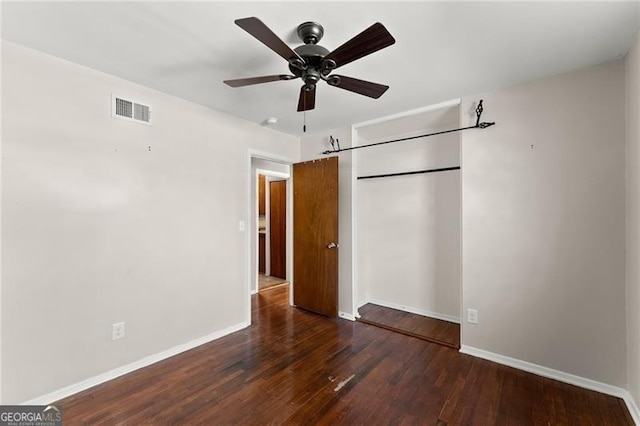 unfurnished bedroom featuring a closet, visible vents, ceiling fan, wood finished floors, and baseboards