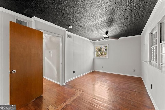 unfurnished room with an ornate ceiling, visible vents, crown molding, and wood finished floors