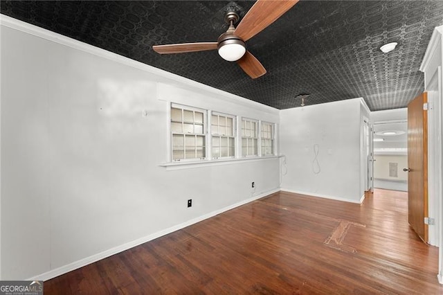 unfurnished room with baseboards, ornamental molding, and wood finished floors