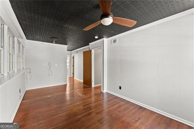 unfurnished room with wood finished floors, visible vents, baseboards, a ceiling fan, and ornamental molding