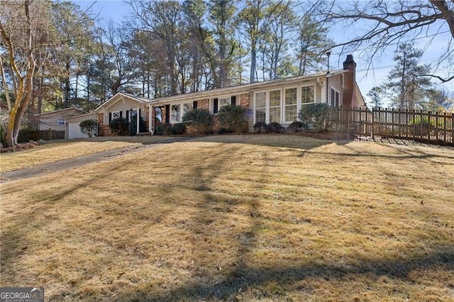 ranch-style home with fence, a chimney, and a front lawn