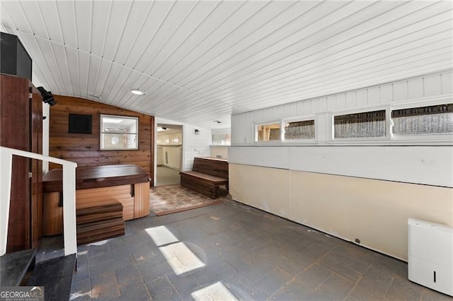 bathroom with wood walls and vaulted ceiling