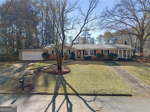 single story home with aphalt driveway, an attached garage, fence, a front lawn, and brick siding