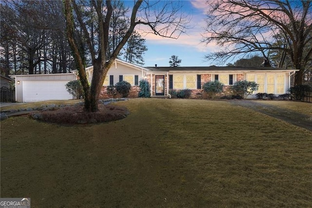 ranch-style house with an attached garage and a lawn