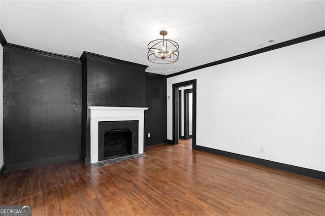 unfurnished living room featuring baseboards, a fireplace, wood finished floors, and crown molding