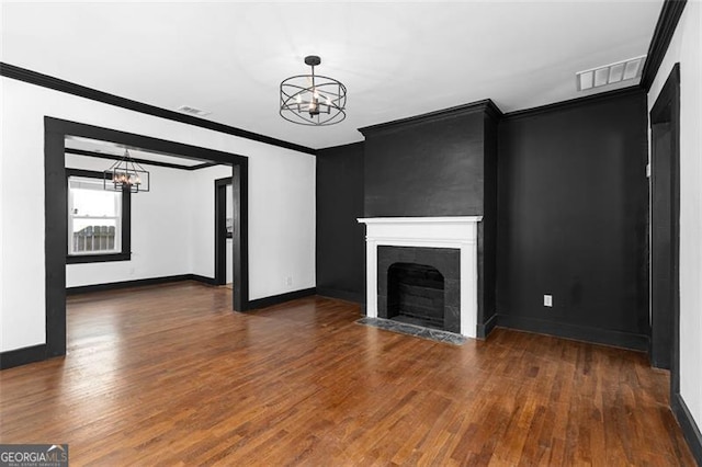 unfurnished living room with crown molding, a fireplace with flush hearth, and an inviting chandelier