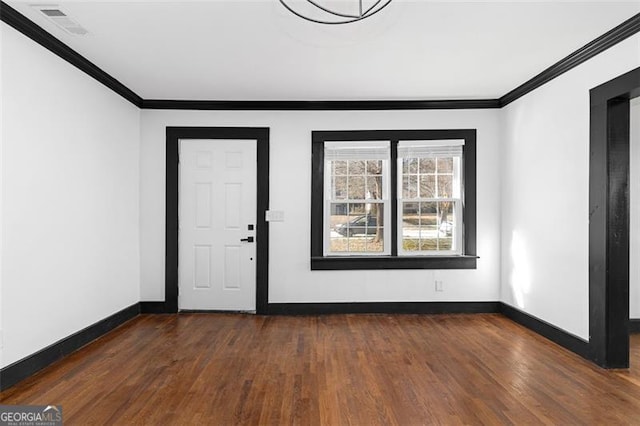 spare room featuring baseboards, ornamental molding, and wood finished floors