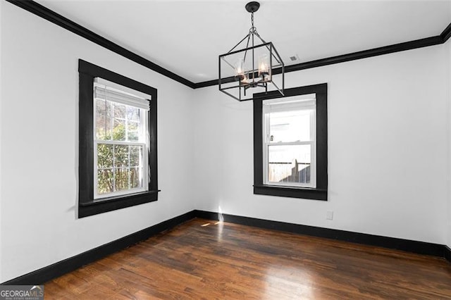 unfurnished dining area with an inviting chandelier, baseboards, dark wood-type flooring, and crown molding