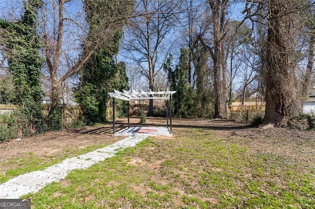 view of yard featuring fence and a pergola