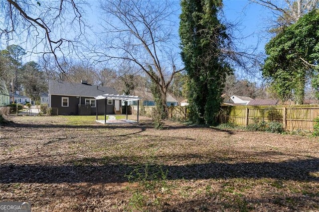 view of yard featuring a carport, a patio area, a fenced backyard, and a pergola