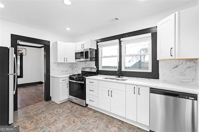 kitchen featuring light countertops, visible vents, appliances with stainless steel finishes, white cabinetry, and a sink