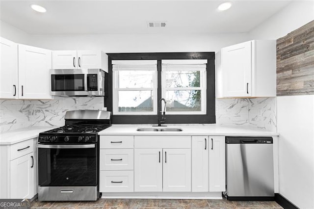 kitchen with stainless steel appliances, white cabinets, light countertops, and a sink