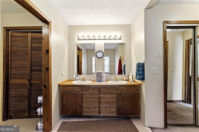 1505 Ozora Rd, Loganville, GA 30052 - bathroom featuring a textured ceiling, double vanity, and a sink