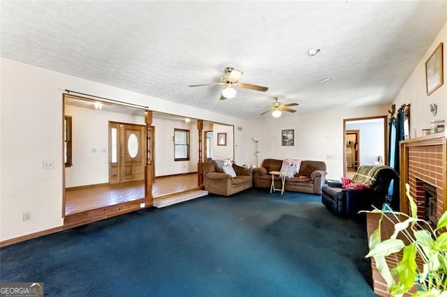 1505 Ozora Rd, Loganville, GA 30052 - interior space featuring baseboards, ceiling fan, a textured ceiling, carpet floors, and a fireplace