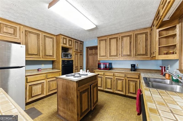 1505 Ozora Rd, Loganville, GA 30052 - kitchen featuring stainless steel appliances, a sink, tile counters, a center island, and open shelves