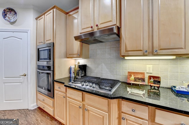 kitchen featuring appliances with stainless steel finishes, crown molding, light brown cabinetry, under cabinet range hood, and backsplash