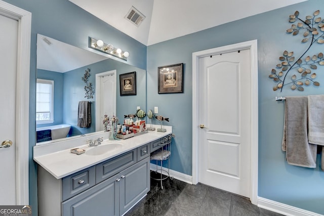 bathroom featuring lofted ceiling, vanity, visible vents, and baseboards