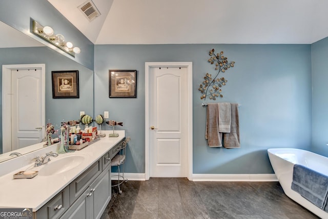 full bathroom with visible vents, a freestanding bath, vanity, and baseboards